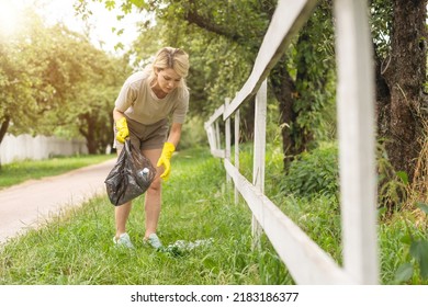 Woman Wearing Latex Gloves Picking Up Litter To Garbage Bag, Holding Used Plastic Bottle In Hand, Takes Care Of Planet