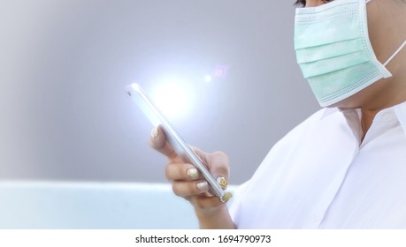 Woman Wearing A Mask And Checking Mobile Phone For Data About Pollution Before Apply Alcohol Gel To Make Cleaning And Clear Germ, Bacteria, Health Care Concept