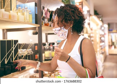 A Woman Wearing A Mask Looking At Products Inside A Store In A Shopping Center. Selective Focus. Concept Of Safe Shopping And Social Distancing.