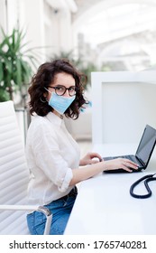 Woman Wearing Mask In Office. Protection Employees And Hygiene On Safe Workplace. Receptionist Working At Reception In Hotel. Social Distancing During Coronavirus Quarantine, Staff Safety.