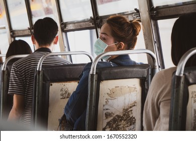 A woman wearing mask protective for spreading of disease virus Covid-19 and air smog pollution with PM 2.5 on bus public in  Bangkok city, Thailand.