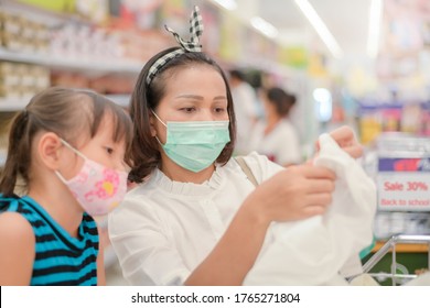 Woman Wearing A Mask In Supermarket She Is Chooses To Buy A New School Uniform For The Children When Their Kids Go Back To School.new Normal