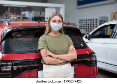 Woman Wearing Medical Face Mask, Leaning On A New Car At Auto Dealership