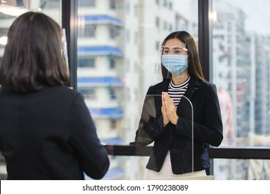 Woman Wearing Medical Mask And Face Shield Protect Against Airborne Disease Visitor Greeting Wai (Thai Greetings) Form Of Thai Culture Instead Of Handshake For Prevent Infection Coronavirus Covid 19.