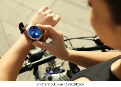 Woman wearing modern smart watch during training outdoors, closeup - Powered by Shutterstock