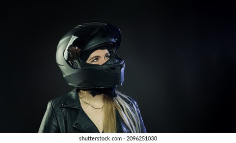 A Woman Wearing A Motorcycle Helmet On A Dark Background. The Concept Of Space.