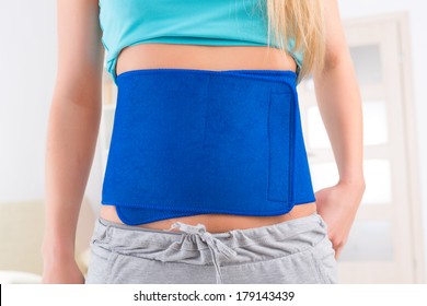 Woman Wearing Neoprene Slimming Belt At Home