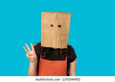 Woman Wearing Paper Bag Over Her Head Holding Up Three Fingers