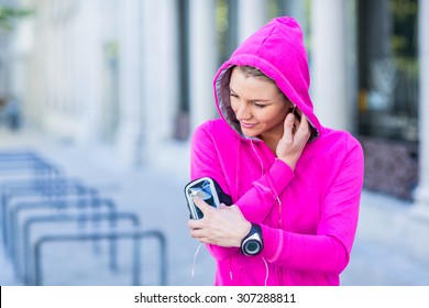 A woman wearing a pink jacket using her phone on a sunny day - Powered by Shutterstock