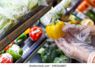 Woman Wearing Plastic Gloves Handing A Plastic Bag With Some Fruits.shopping Concept.