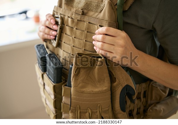 Woman\
is wearing a protective body armor and hiking\
kit