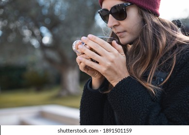 Woman Wearing Red Beanie And Sunglasses Drinking Tea Outdoor