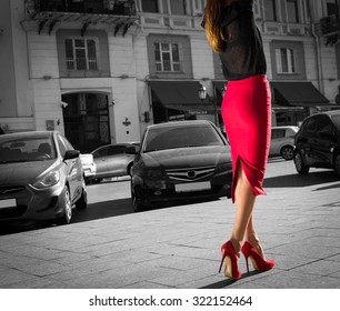 Woman Wearing Red Elegant Skirt  And Red High Heel Shoes In Old Town.Young Beautiful Business Sexy Woman Walking,urban Background.Back View Of A Fashion Shopper Woman Legs. Black And White Concept.