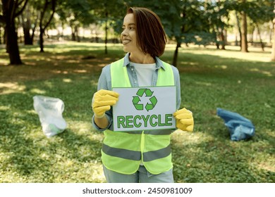 Woman wearing safety vest holds recycle sign, promoting sustainability, eco-friendly action. - Powered by Shutterstock