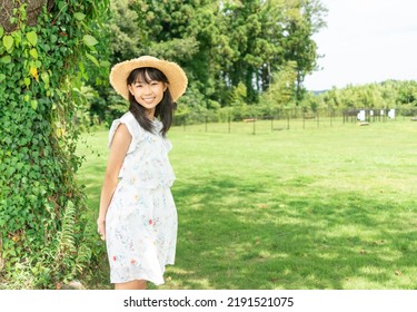 Woman Wearing A Straw Hat Resting In The Shade Of A Tree