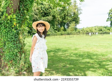 Woman Wearing A Straw Hat Resting In The Shade Of A Tree