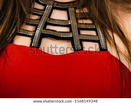 Woman wearing stylish elegant red dress, detail view, decorative neckline