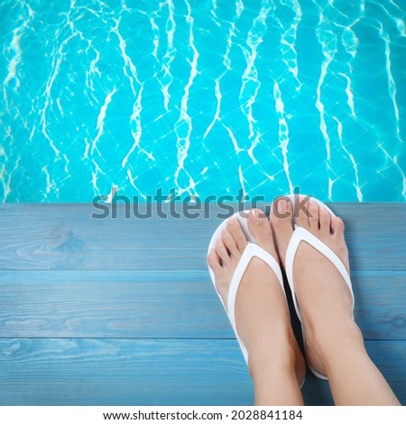 Woman wearing stylish flip flops near swimming pool, top view