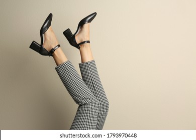 Woman wearing stylish shoes on beige background, closeup. Space for text