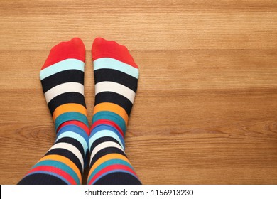 Woman wearing stylish socks standing on floor, top view. Space for design