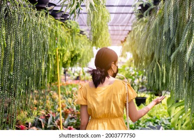 Woman Wearing Surgical Face Mask And Buying Plants At Garden Center