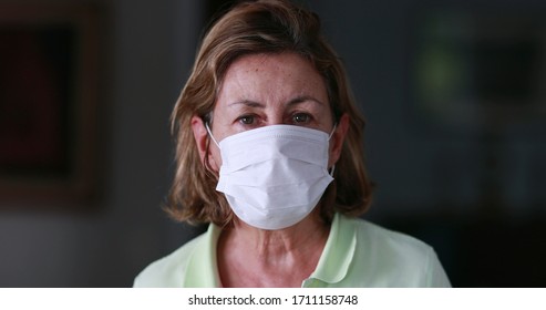 Woman Wearing Surgical Mask Epidemic Prevention Covering Face. Senior Woman In Late 60s Using Mask Looking To Camera