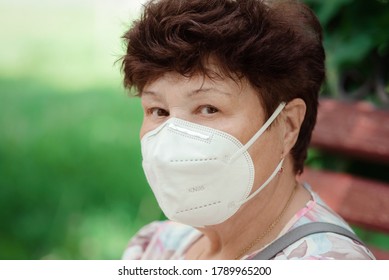 Woman Wearing Surgical Mask Epidemic Prevention Covering Face. Senior Woman In Late 60s Using Mask Looking To Camera.