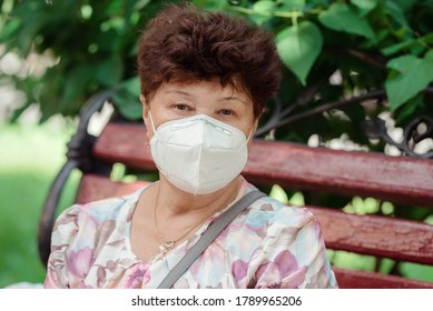 Woman Wearing Surgical Mask Epidemic Prevention Covering Face. Senior Woman In Late 60s Using Mask Looking To Camera.