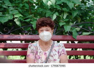 Woman Wearing Surgical Mask Epidemic Prevention Covering Face. Senior Woman In Late 60s Using Mask Looking To Camera.