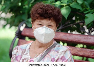 Woman Wearing Surgical Mask Epidemic Prevention Covering Face. Senior Woman In Late 60s Using Mask Looking To Camera.