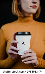 Woman wearing a turtleneck with a takeout paper cup mockup