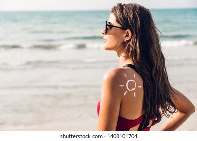 Woman Wearing Two Piece Bikini Applying Suncream With Sun Drawn On Back On The Tropical Beach.Summer Vacations