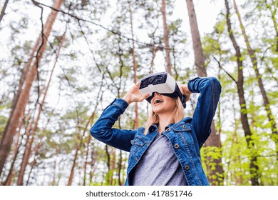 Woman Wearing Virtual Reality Goggles Outside In Spring Nature. VR Glasses. 360 Degrees. Virtual Reality Headset. VR Game. Wearing Virtual Reality Goggles. Smartphone With VR. Virtual Reality Video.