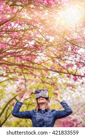 Woman Wearing Virtual Reality Goggles Outside In Spring Nature. VR Glasses. 360 Degrees. Virtual Reality Headset. VR Game. Wearing Virtual Reality Goggles. Smartphone With VR. Virtual Reality Video.