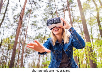 Woman Wearing Virtual Reality Goggles Outside In Spring Nature. VR Glasses. 360 Degrees. Virtual Reality Headset. VR Game. Wearing Virtual Reality Goggles. Smartphone With VR. Virtual Reality Video.