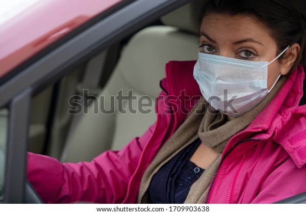 Woman wearing\
virus protection mask in the\
car