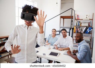 Woman Wearing VR Goggles Watched By Colleagues In An Office