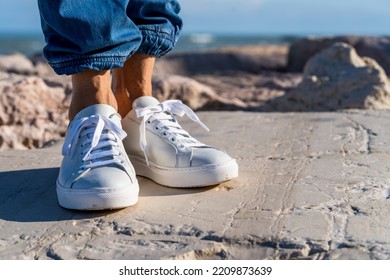 Woman Wearing White Leather Sneakers Outdoors.