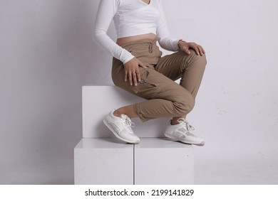 Woman Wearing White Shirt And Beige Pants Taking A Photo In The Studio