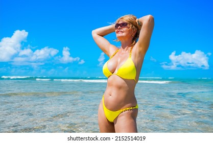 Woman wearing yellow bikini on tropical beach