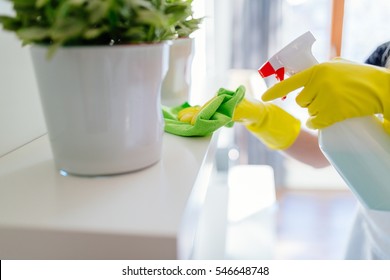 Woman Wearing Yellow Rubber Protective Gloves And Cleaning White Shelf.