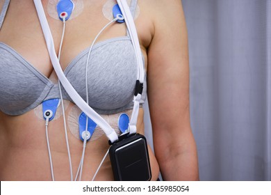 A woman wears a General Electric brand Seer Light Holter, an ambulatory electrocardiography device, to monitor the electrical activity of her cardiovascular system. Health, disease concept. Real foto.