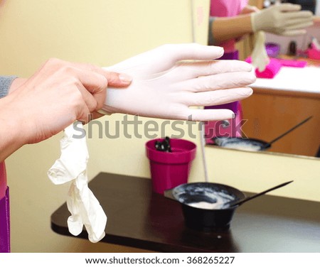 woman wears gloves and prepares to apply hair color closeup