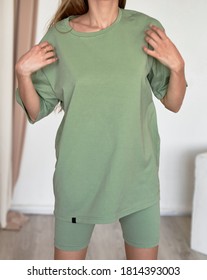 Woman Wears Green Oversize T Shirt With Copy Space. Indoor Studio Clothes Mockup