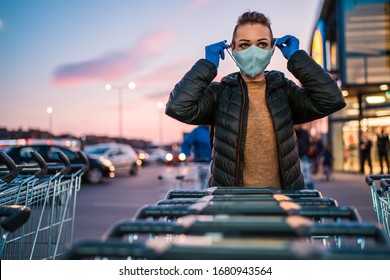 Eine Frau trägt beim Einkaufen medizinische Schutzhandschuhe und eine Maske.