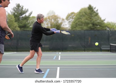 A Woman Wears Rubber Gloves While Playing Pickleball