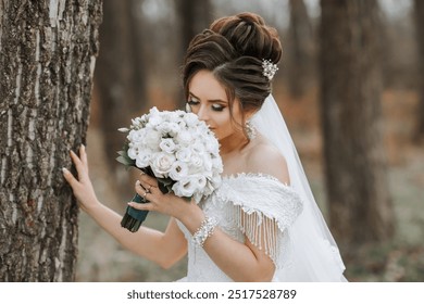 A woman in a wedding dress is holding a bouquet of white flowers and sniffing them. Concept of romance and celebration, as the woman is likely getting ready for a wedding or a special event - Powered by Shutterstock