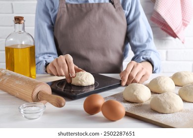 Woman weighing raw dough ball on kitchen scale at white wooden table, closeup - Powered by Shutterstock