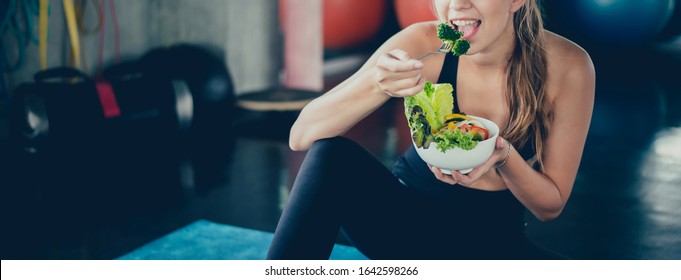 Woman  Wellness By Eat Salad After Exercise At Fitness Gym. Sport Women With Healthy Food. Workout Alone And Social Distancing.