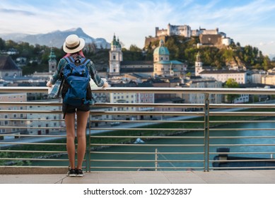 Woman westerner travel in backpack with map looking at city view of Castle SalzburgCity in Austria